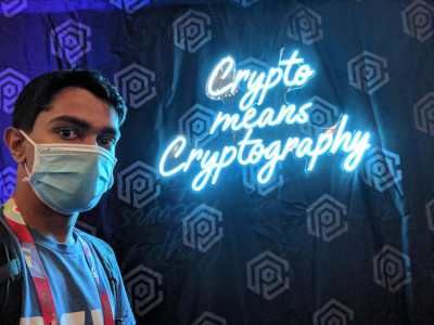 A selfie of me in front of a neon 'Crypto means Cryptography' sign